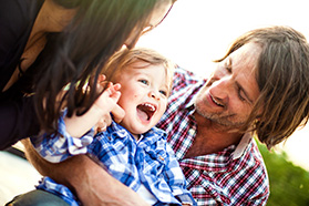 Two parents play with a young child.